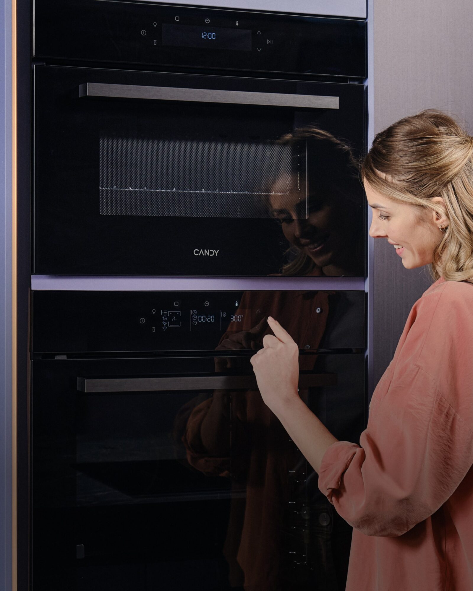 Woman using Candy built-in ovens