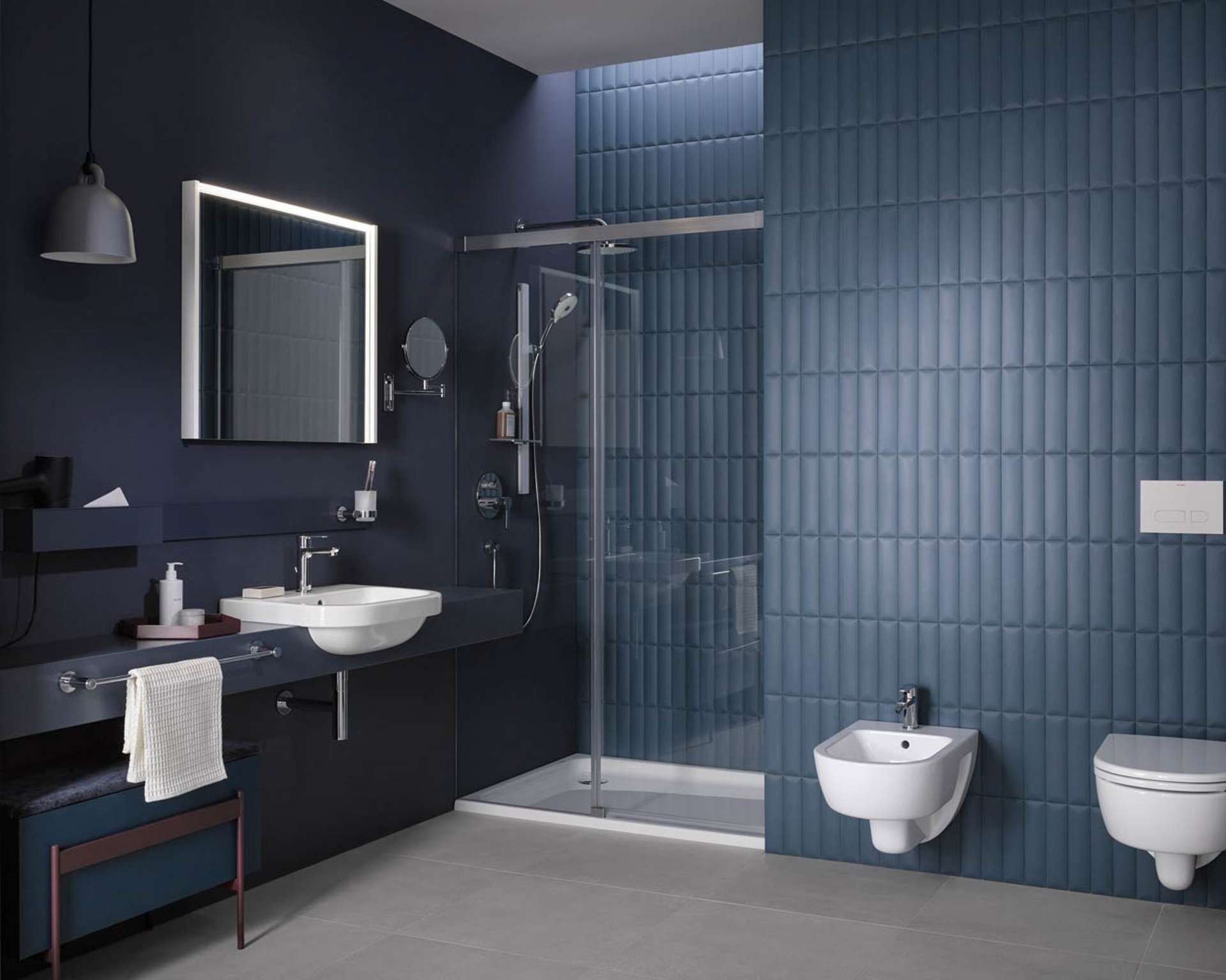 Duravit D-Code bathroom with a shower enclosure and wall hung toilet against blue tiles