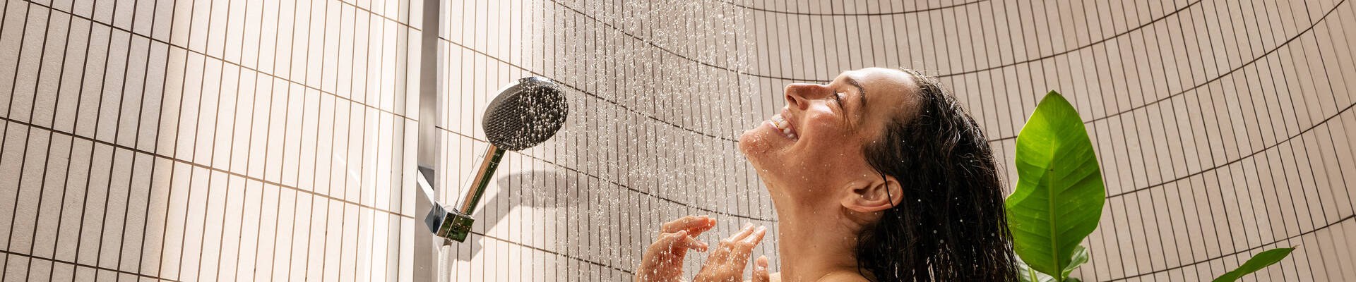 Woman showering under a hansgrohe Raindance Alive overhead shower