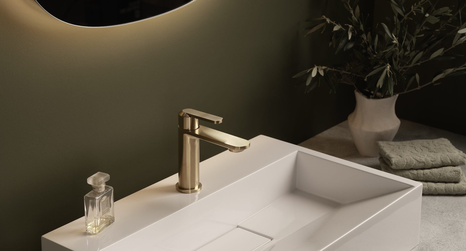 JTP basin mixer tap in a brushed finish on a vanity with a plant and soap dish