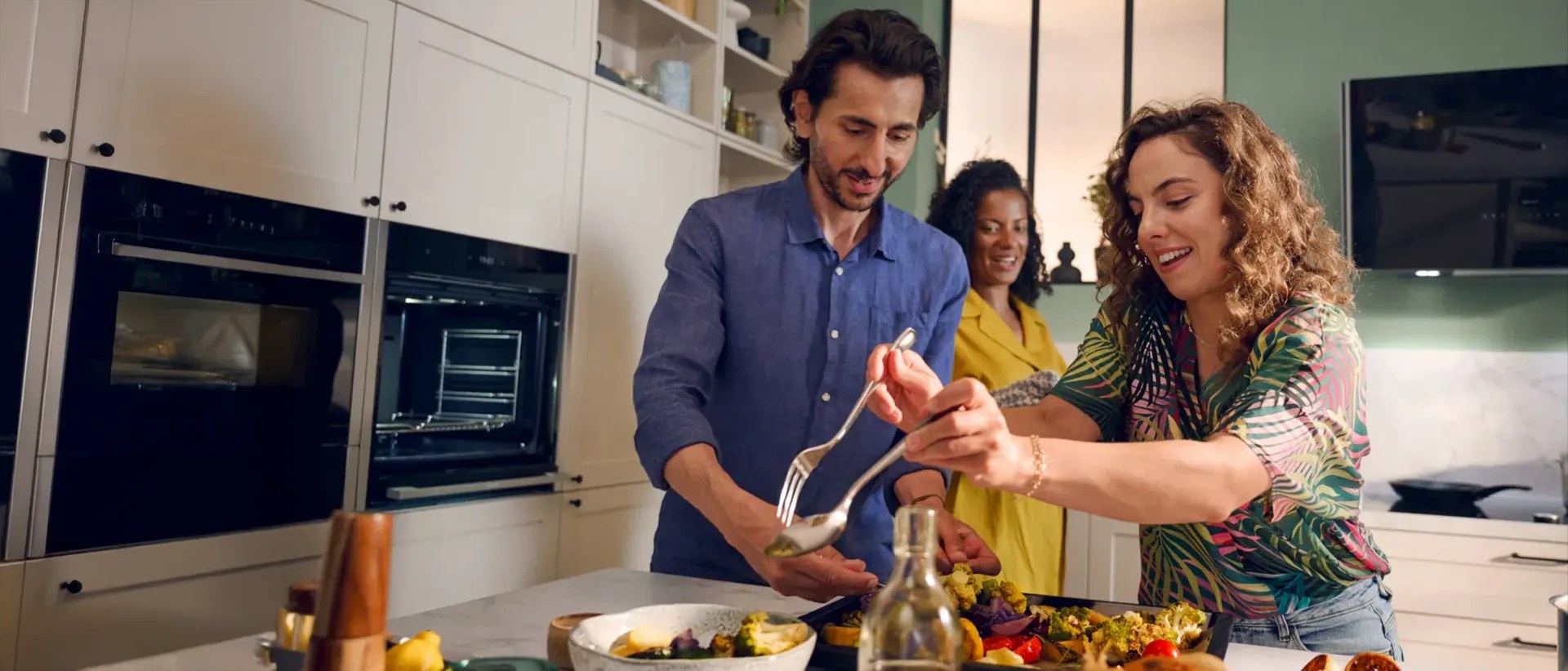 Family cooking in a kitchen with Neff built-in ovens