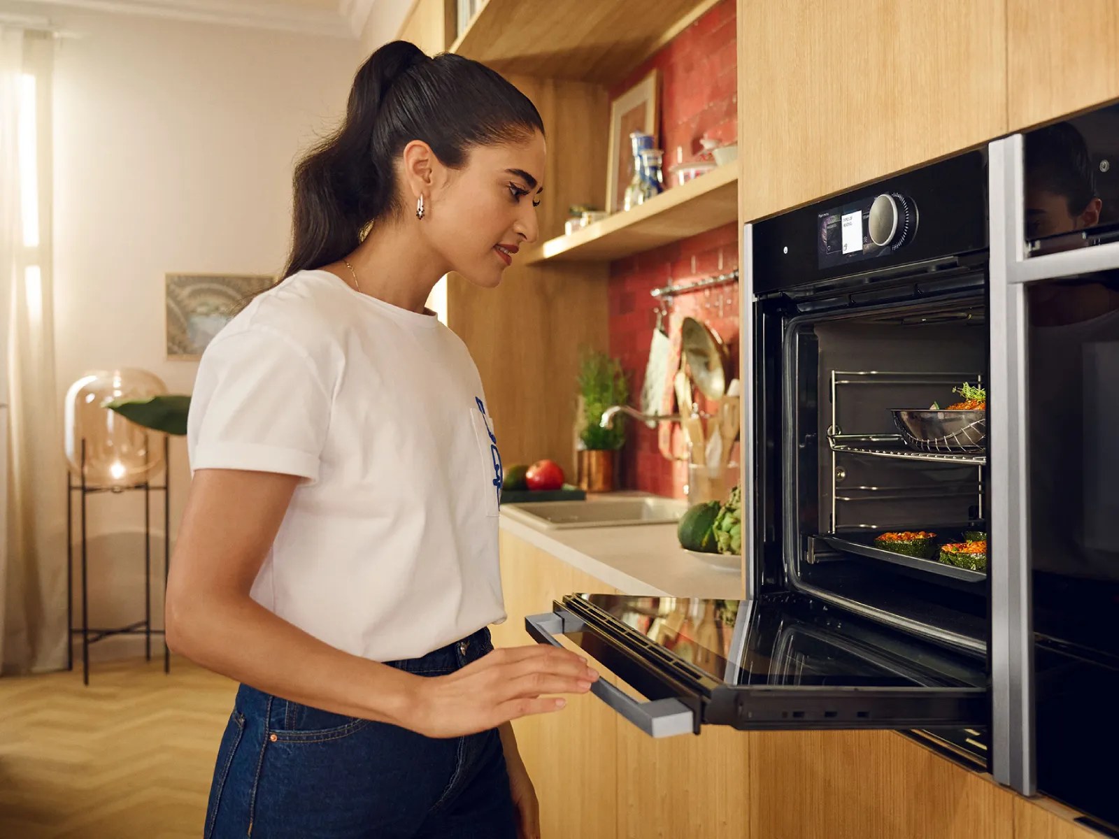 Woman opening the door of a Neff Slide and Hide oven